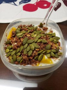 high protein breakfast with greek yogurt, pumpkin seeds, protein granola and mango